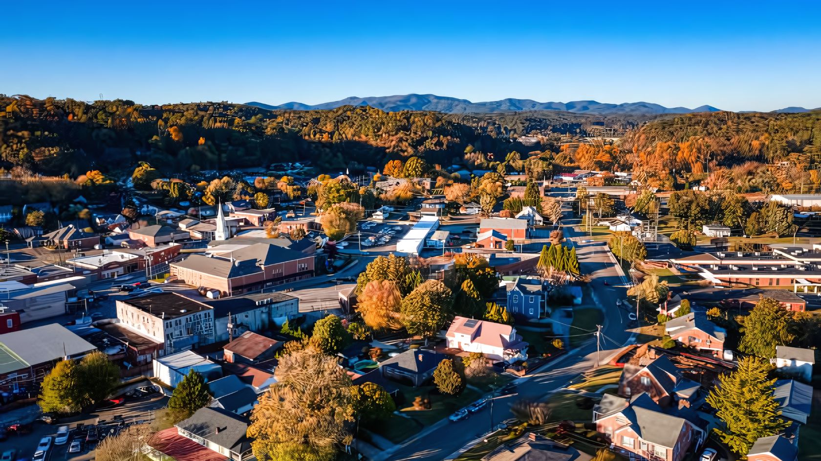 a city with trees and mountains in the background